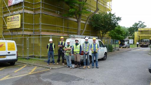 Poulton Remedial team in Hi-Viz vests and hardhats in-front of scaffolding highlighting their commitment to safety 