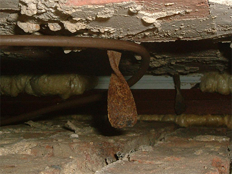 Corroded cavity wall tie that has resulted in the wall skins failing