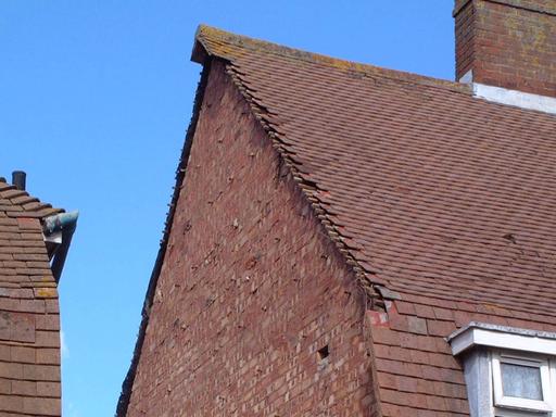 Side of home showing the absence of a gable due to it falling down in strong winds